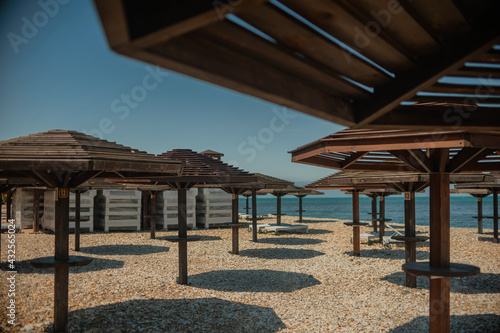 Wooden beach umbrellas by the sea in clear weather