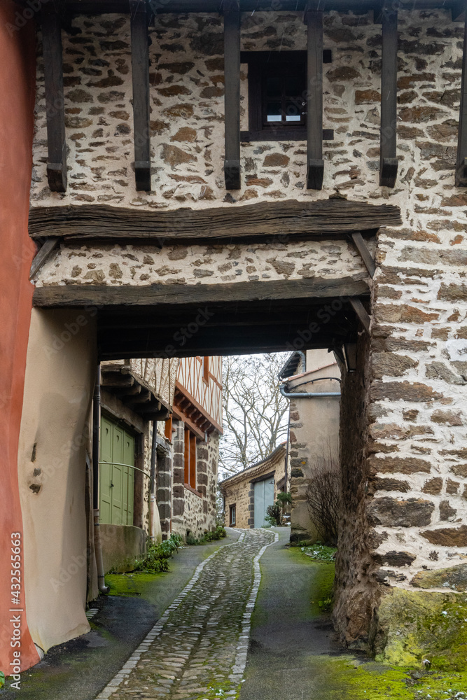 ruelle médiévale traversant un porche de bois