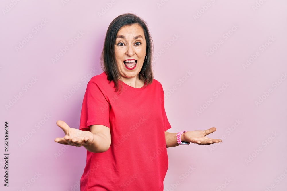 Middle age hispanic woman wearing casual clothes smiling cheerful with open arms as friendly welcome, positive and confident greetings Middle age hispanic woman wearing casual clothes smiling cheerful with open arms as friendly welcome, positive and confident greetings