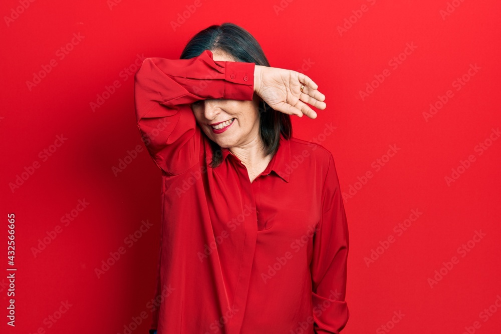 Middle age hispanic woman wearing casual clothes covering eyes with arm smiling cheerful and funny. blind concept. Middle age hispanic woman wearing casual clothes covering eyes with arm smiling cheerful and funny. blind concept.