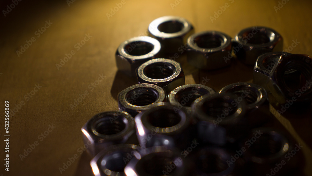screw nuts on a wooden table screw nuts on a wooden table