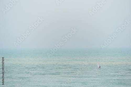Tiny Optimist dinghy alone on wide ocean