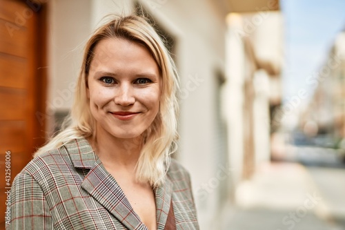 Young blonde businesswoman smiling happy standing at the city. Free Download Young blonde businesswoman smiling happy standing at the city. - GFXLoad