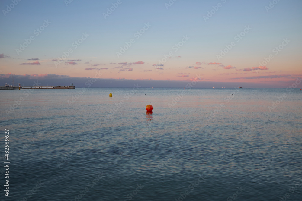 Beautiful calm evening sea with red buoy