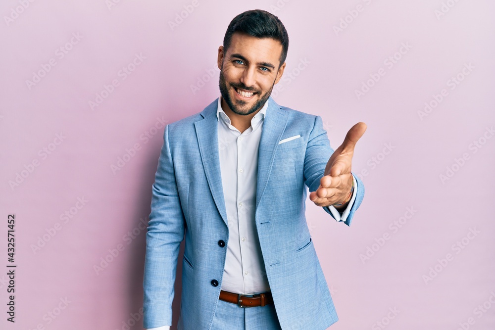 Young hispanic businessman wearing business jacket smiling friendly offering handshake as greeting and welcoming. successful business. Young hispanic businessman wearing business jacket smiling friendly offering handshake as greeting and welcoming. successful business.