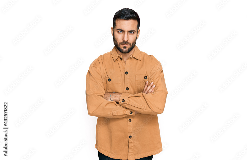 Young hispanic man wearing casual clothes skeptic and nervous, disapproving expression on face with crossed arms. negative person. Young hispanic man wearing casual clothes skeptic and nervous, disapproving expression on face with crossed arms. negative person.