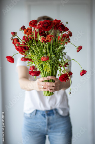 Girl holds a bouquet of red flowers