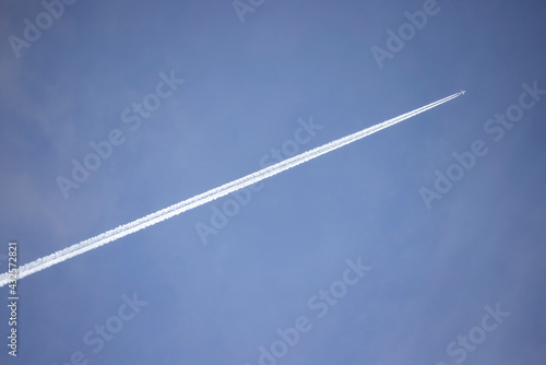 Jetstream follows white plane three quarters of the way across a blue mottled sky