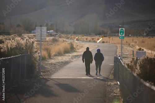 A couple backlit with sun flare on a walking path in rural nevada