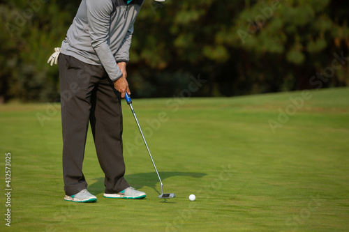 Man playing golf, putting green
