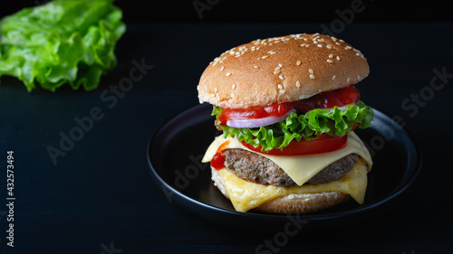 Close-up home made beef burger on wooden table. Space for text.