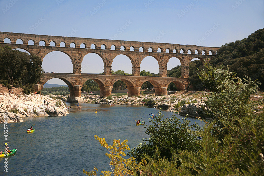 Pont du Gard, Gard, Occitanie, France: Roman aqueduct over Gardon river: general view from upstream with canoeists