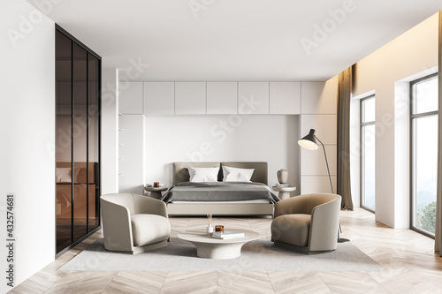 White bedroom interior with armchairs and bed on parquet floor with windows © ImageFlow