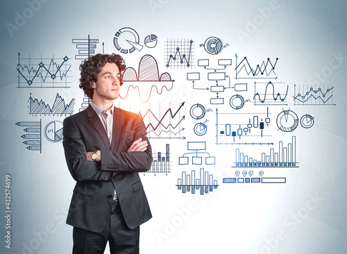 Businessman in black suit standing on background of graph sketch