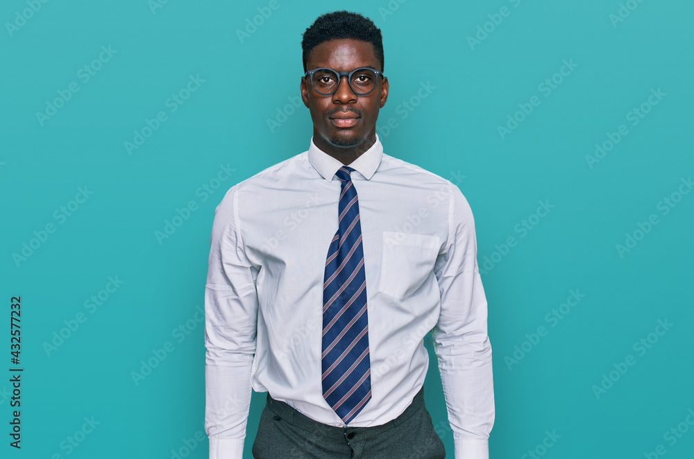 Handsome business black man wearing white shirt and tie with serious expression on face. simple and natural looking at the camera. Handsome business black man wearing white shirt and tie with serious expression on face. simple and natural looking at the camera.