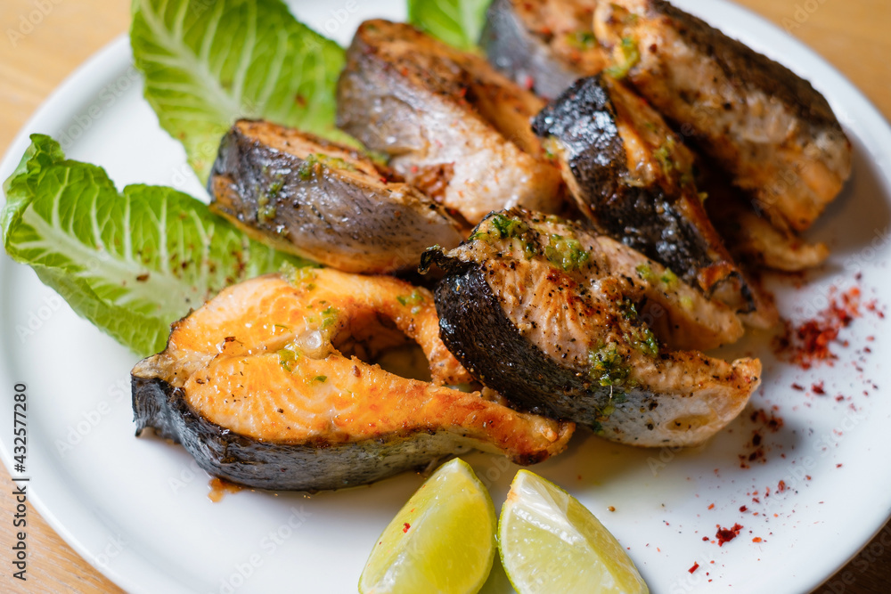 Baked fish with herbs and lemon. Seafood on white plate top view. Baked fish with herbs and lemon. Seafood on white plate top view.