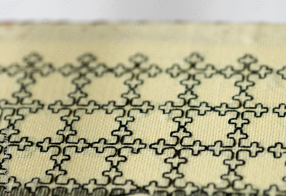 Naklejka premium simple blackwork embroidery on pale yellow even-weave cloth on a white background - book-covers