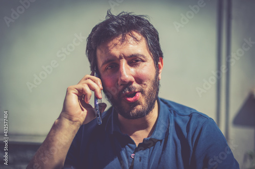 Young caucasian man with beard smiling happy talking on the smartphone