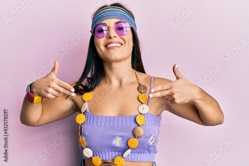 Young brunette woman wearing bohemian and hippie style looking confident with smile on face, pointing oneself with fingers proud and happy.