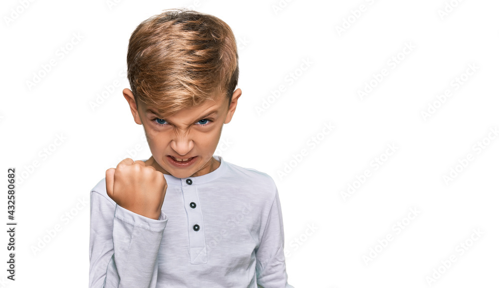 Little caucasian boy kid wearing casual clothes angry and mad raising fist frustrated and furious while shouting with anger. rage and aggressive concept. Little caucasian boy kid wearing casual clothes angry and mad raising fist frustrated and furious while shouting with anger. rage and aggressive concept.