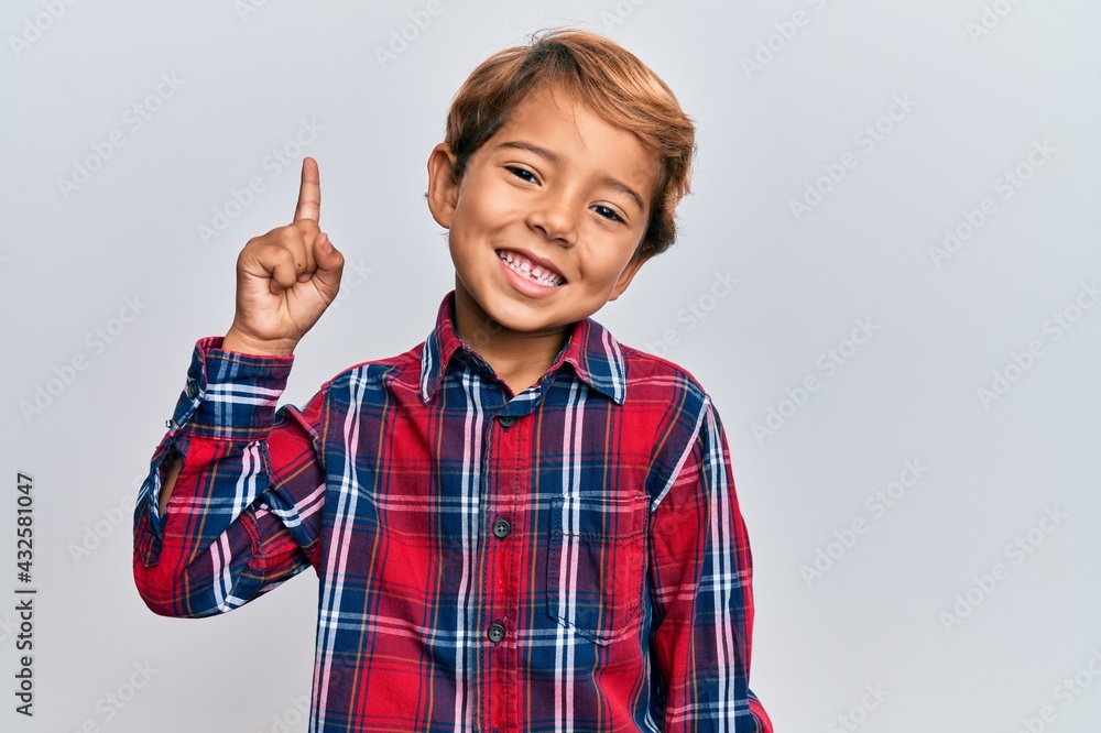 Adorable latin kid wearing casual clothes smiling with an idea or question pointing finger up with happy face, number one Adorable latin kid wearing casual clothes smiling with an idea or question pointing finger up with happy face, number one