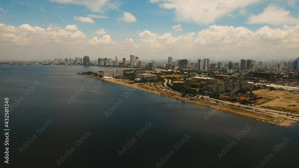 Aerial view of Manila city. Fly over city with skyscrapers and buildings. Aerial skyline of Manila . Modern city by sea, highway, cars, skyscrapers, shopping malls. Makati district. Travel concept.