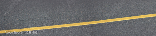 Panorama of asphalt texture with a long yellow line.