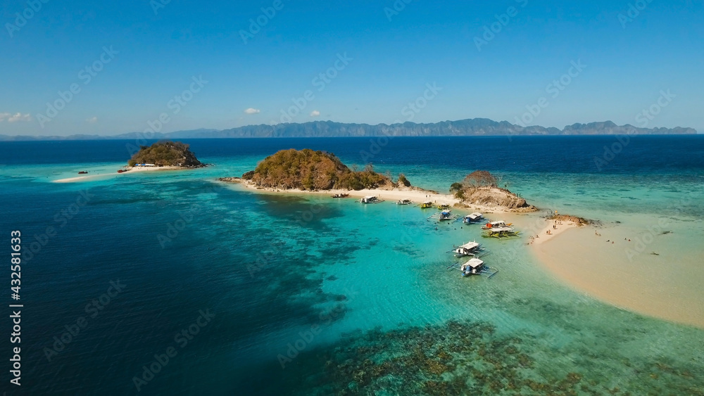 Fototapeta premium Aerial view of tropical beach on the island, Philippines. Beautiful tropical island with sand beach, palm trees. Tropical landscape: beach with palm trees. Seascape: Ocean, sky, sea. 4K video.