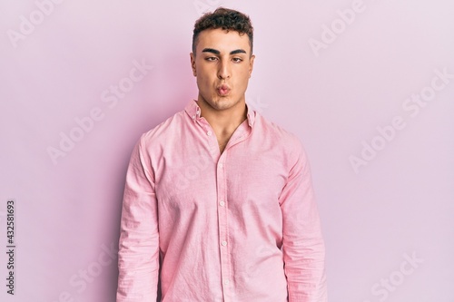 Hispanic young man wearing casual clothes making fish face with lips, crazy and comical gesture. funny expression. © Krakenimages.com