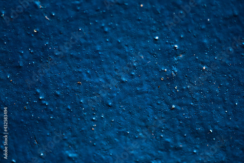 Grain blue dribbled paint wall background or texture.