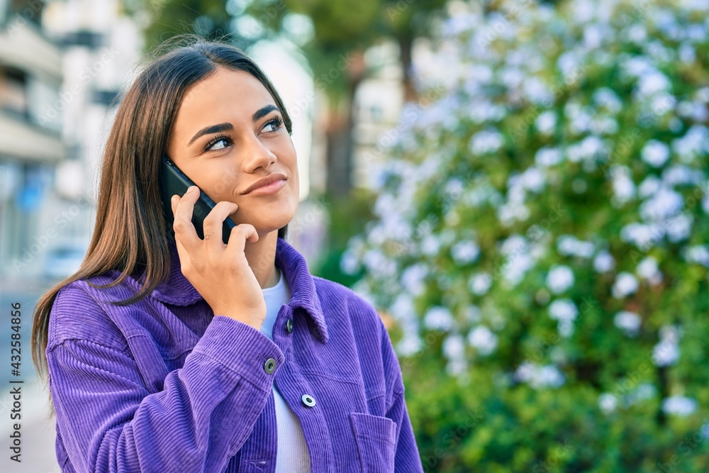 Young hispanic woman smiling happy talking on the smartphone at the park. Young hispanic woman smiling happy talking on the smartphone at the park.