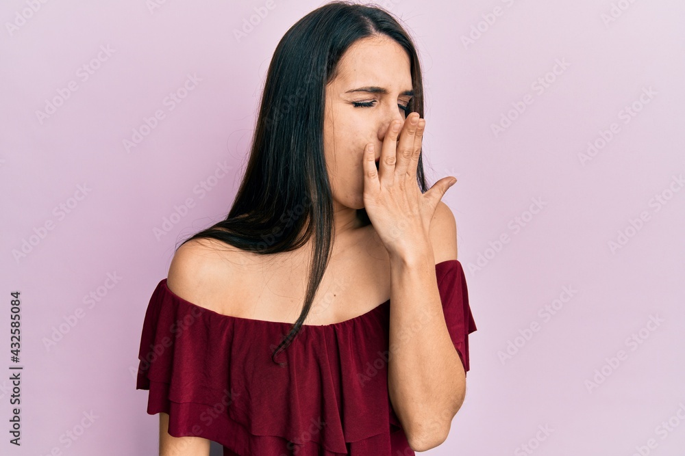 Young hispanic woman wearing casual clothes bored yawning tired covering mouth with hand. restless and sleepiness. Young hispanic woman wearing casual clothes bored yawning tired covering mouth with hand. restless and sleepiness.