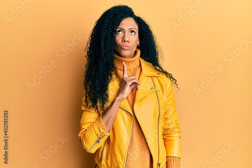 Fotografie Middle age african american woman wearing wool winter sweater and leather jacket