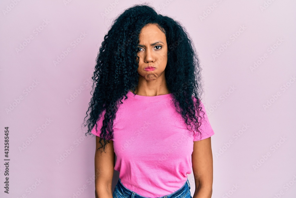 Middle age african american woman wearing casual clothes puffing cheeks with funny face. mouth inflated with air, crazy expression. Middle age african american woman wearing casual clothes puffing cheeks with funny face. mouth inflated with air, crazy expression.