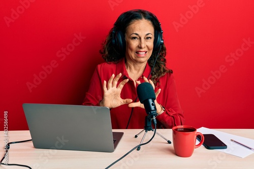 Foto Beautiful middle age woman working at radio studio disgusted expression, displeased and fearful doing disgust face because aversion reaction