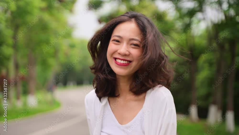 portrait of happy young asian woman looking at camera smile in the nature park portrait of happy young asian woman looking at camera smile in the nature park