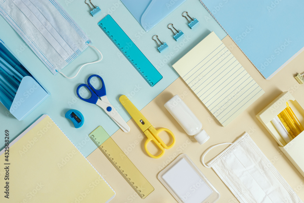 Layout of school supplies, notebooks, pens, pencils, medical mask and hand sanitizer Back to school concept Layout of school supplies, notebooks, pens, pencils, medical mask and hand sanitizer Back to school concept
