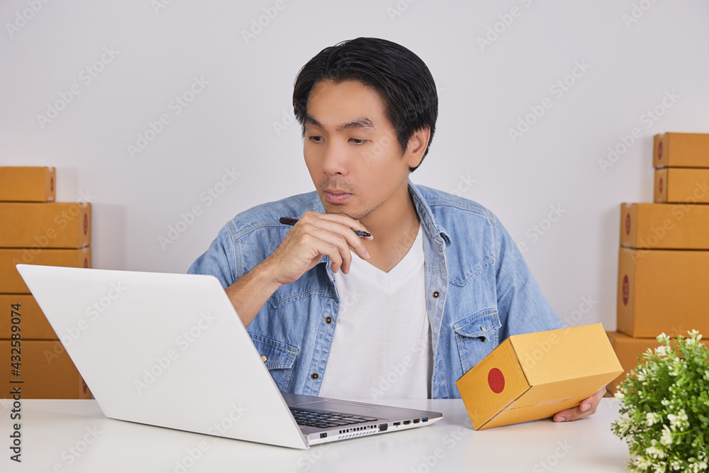 Online Merchant or Casual Businessman in Online Store Hold Parcel and Think about Parcel Shipping Cost Online Merchant or Casual Businessman in Online Store Hold Parcel and Think about Parcel Shipping Cost