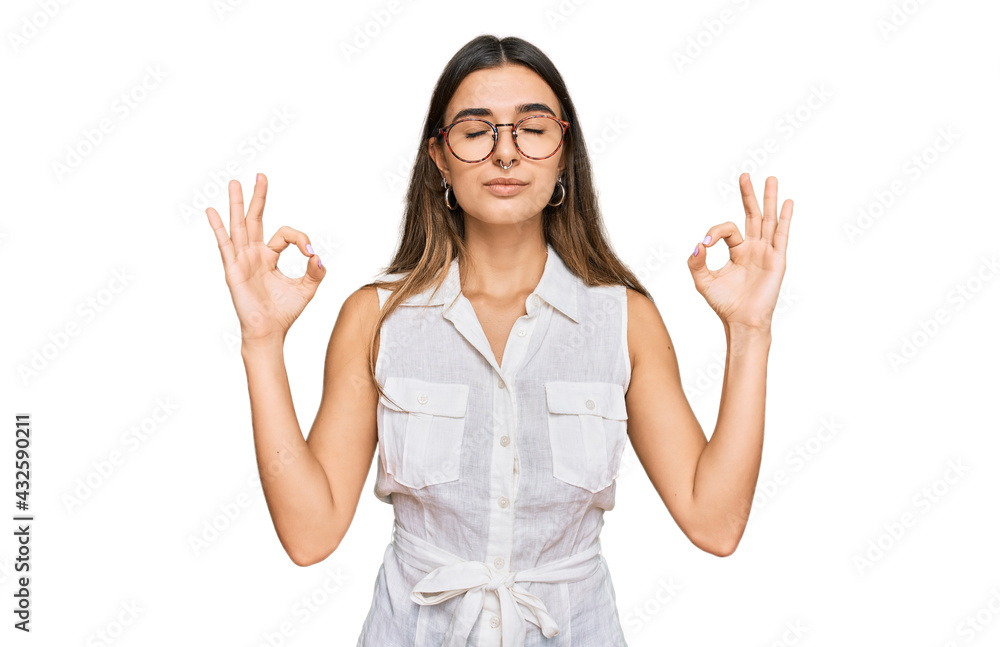 Young hispanic woman wearing casual clothes relax and smiling with eyes closed doing meditation gesture with fingers. yoga concept. Young hispanic woman wearing casual clothes relax and smiling with eyes closed doing meditation gesture with fingers. yoga concept.