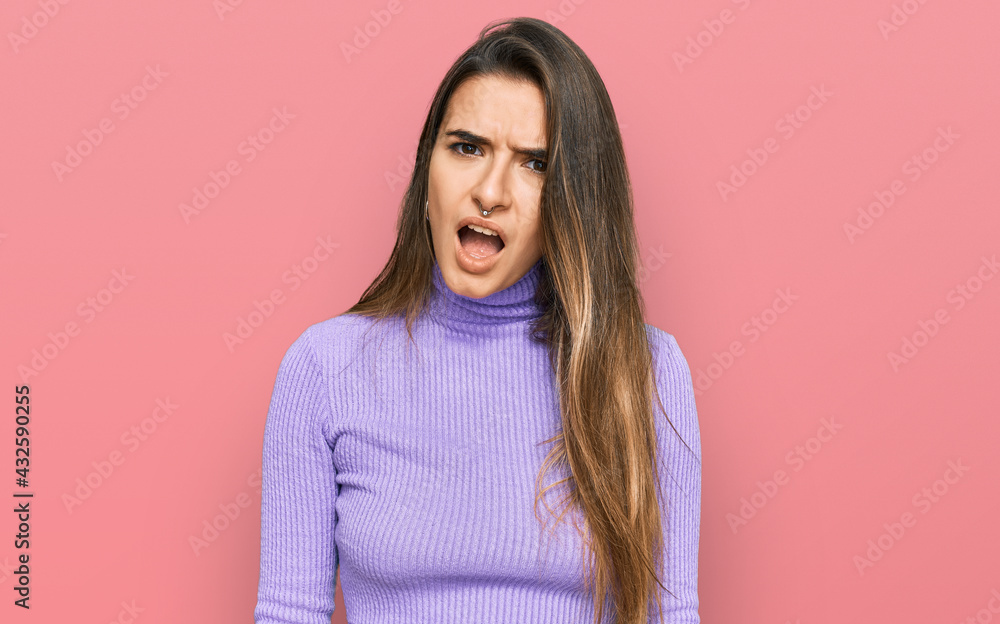 Fototapeta premium Young hispanic woman wearing casual clothes in shock face, looking skeptical and sarcastic, surprised with open mouth