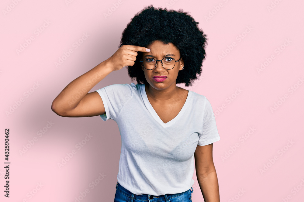 Young african american woman wearing casual white t shirt pointing unhappy to pimple on forehead, ugly infection of blackhead. acne and skin problem Young african american woman wearing casual white t shirt pointing unhappy to pimple on forehead, ugly infection of blackhead. acne and skin problem