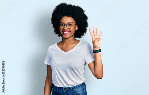 Young african american woman wearing casual white t shirt showing and pointing up with fingers number four while smiling confident and happy.