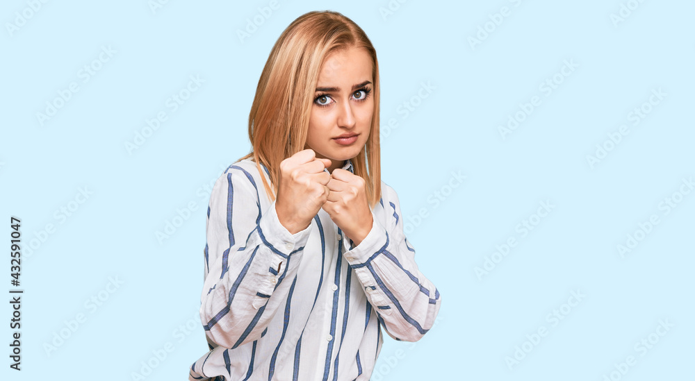 Beautiful caucasian woman wearing casual clothes ready to fight with fist defense gesture, angry and upset face, afraid of problem Beautiful caucasian woman wearing casual clothes ready to fight with fist defense gesture, angry and upset face, afraid of problem