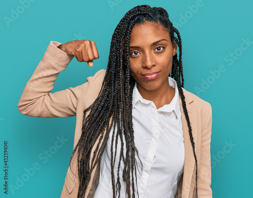 African american woman wearing business jacket strong person showing arm muscle, confident and proud of power
