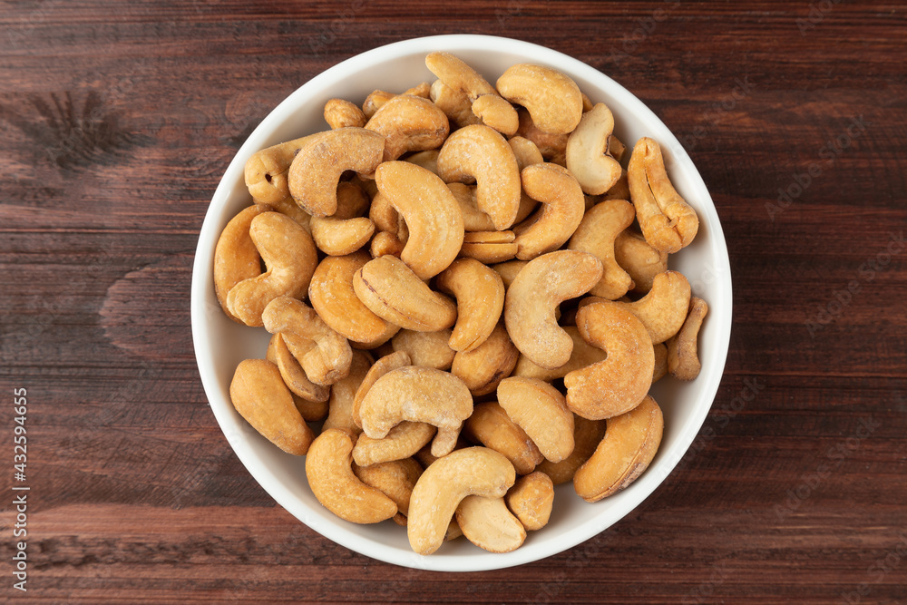 Top view of cashew nuts in white bowl on the table, Flat lay, Healthy snack, Vegetarian food. Top view of cashew nuts in white bowl on the table, Flat lay, Healthy snack, Vegetarian food.