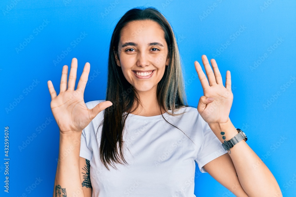 Young hispanic woman wearing casual white t shirt showing and pointing up with fingers number nine while smiling confident and happy. Young hispanic woman wearing casual white t shirt showing and pointing up with fingers number nine while smiling confident and happy.