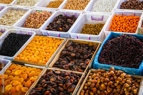 Close-up of beautiful rows of fresh nuts: figs, raisins, dried apricots. Various nuts on the market showcase