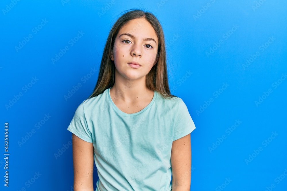 Beautiful brunette little girl wearing casual white t shirt relaxed with serious expression on face. simple and natural looking at the camera. Beautiful brunette little girl wearing casual white t shirt relaxed with serious expression on face. simple and natural looking at the camera.