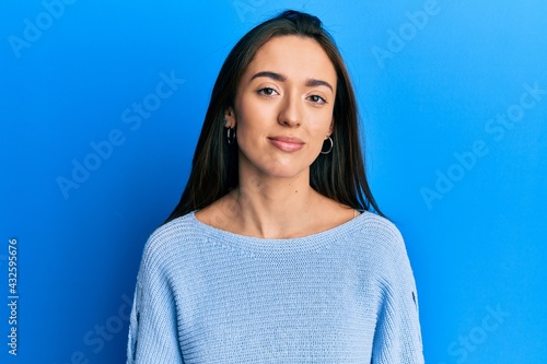 Young hispanic girl wearing casual clothes relaxed with serious expression on face. simple and natural looking at the camera.