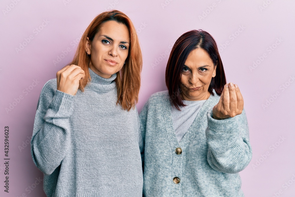 Latin mother and daughter wearing casual clothes doing italian gesture with hand and fingers confident expression Latin mother and daughter wearing casual clothes doing italian gesture with hand and fingers confident expression